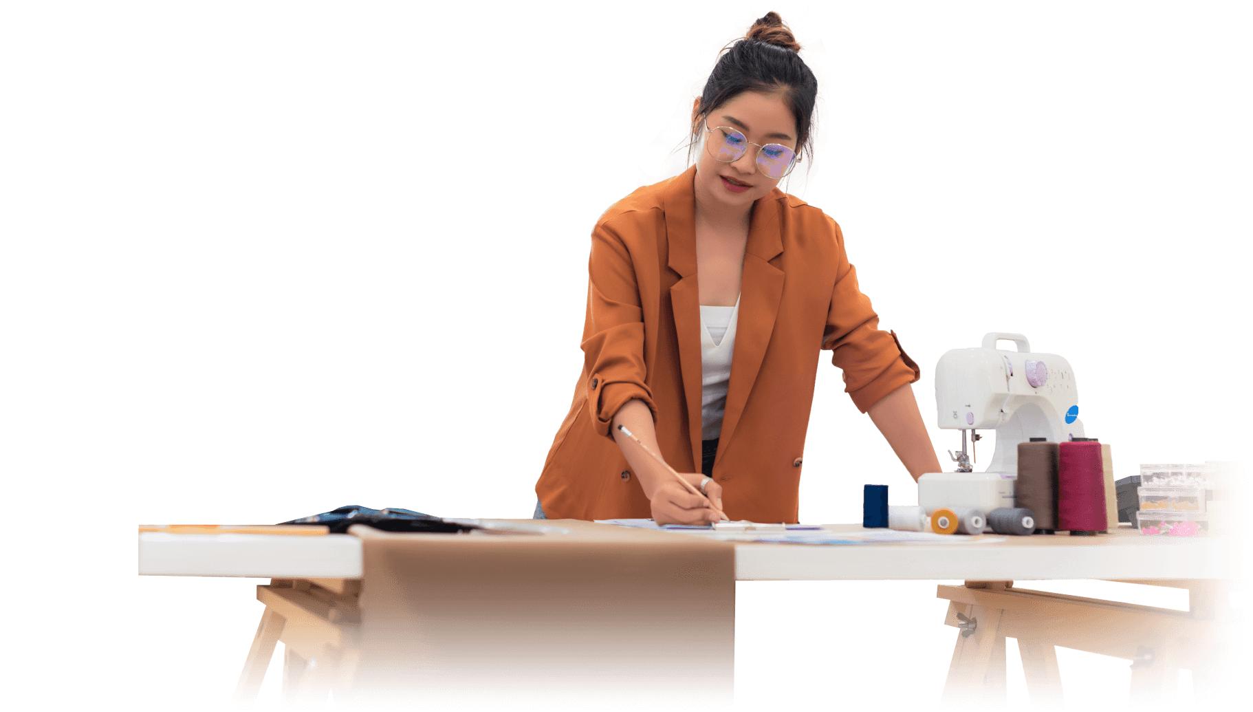 A designer works at a sewing table.